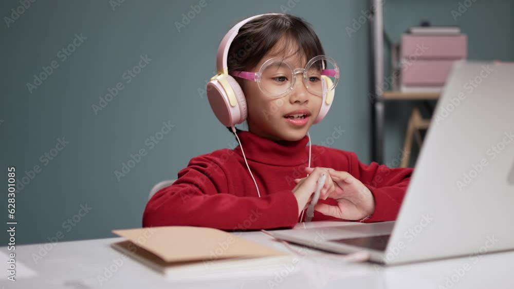 Little girls using a laptop computer for online education.in the living room. Little girls using a laptop computer for online education.in the living room.