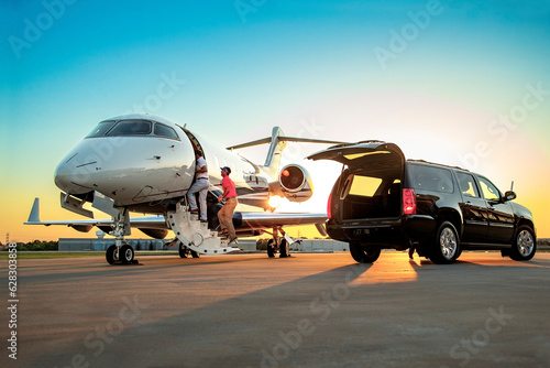 Two men exiting SUV and boarding jet for weekend golf trip on tarmac of small private airport  photo