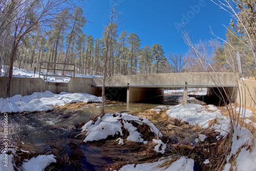 Miller Creek flowing under a bridge at the Thumb Butte Recreation Area in the Prescott National Forest just west of Prescott Arizona, covered in winter snow and ice. photo