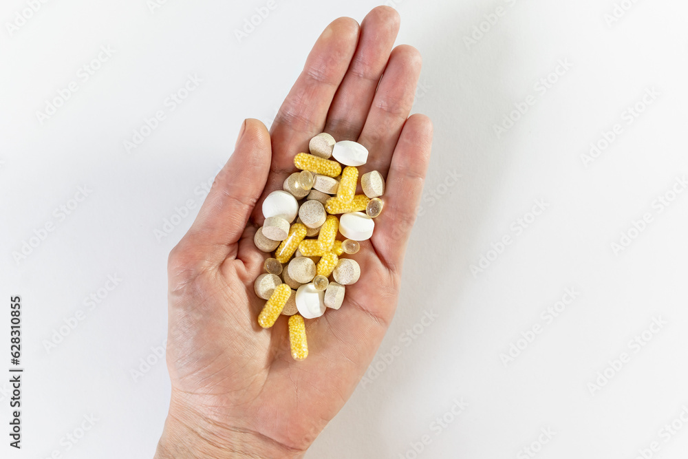 Different pills vitamins on the hand on white table. Medical, vitamins, health background Different pills vitamins on the hand on white table. Medical, vitamins, health background