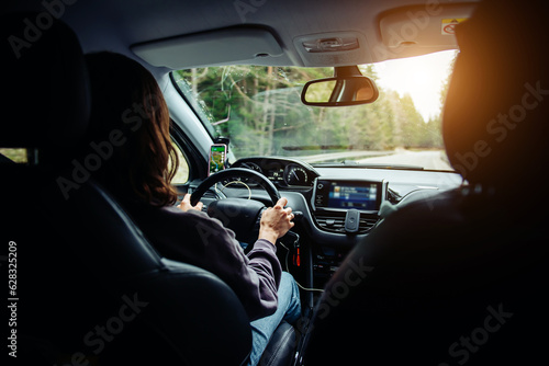 A woman holding the steering wheel tightly and driving a car. Traveling by car © Kate Stock