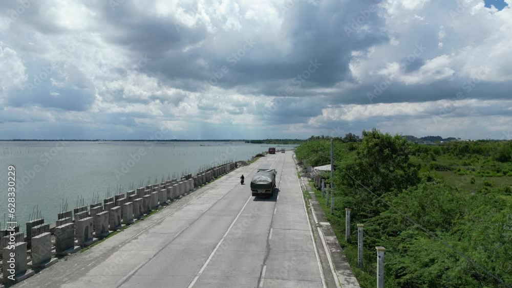 Movement of vehicles on road running along wide body of water Movement of vehicles on road running along wide body of water