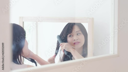 おでかけ前に髪の毛をセットする若い女性