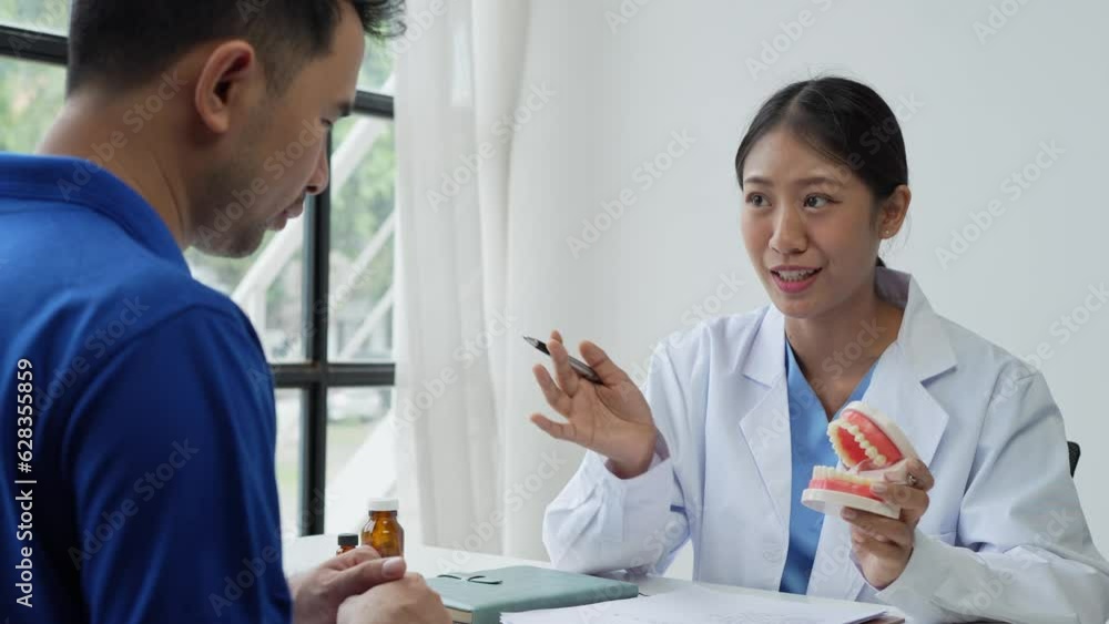 Doctor with educational model of dental implant consulting patient in clinic. Doctor with educational model of dental implant consulting patient in clinic.