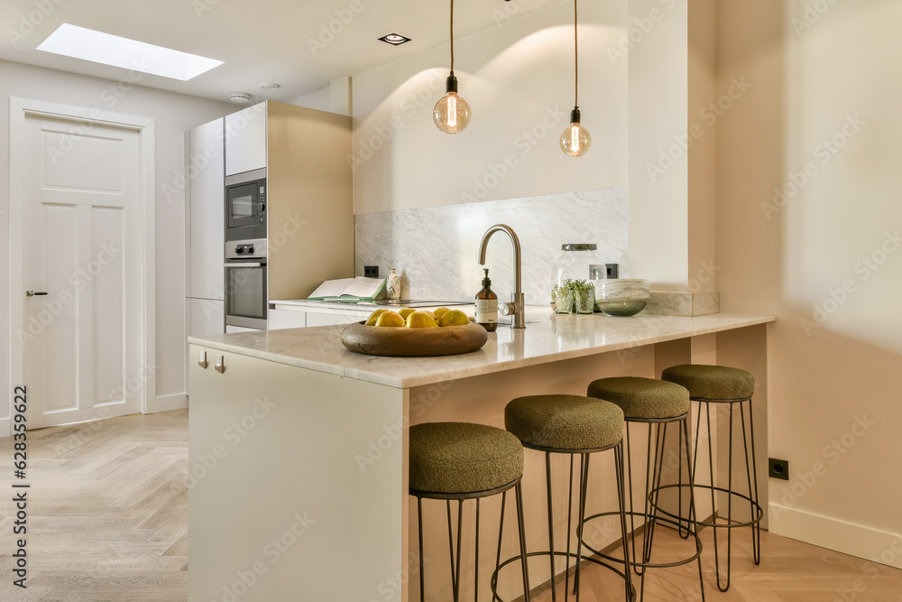 Fototapeta premium a kitchen with three stools and a bowl of fruit on the island in front of the counter is white