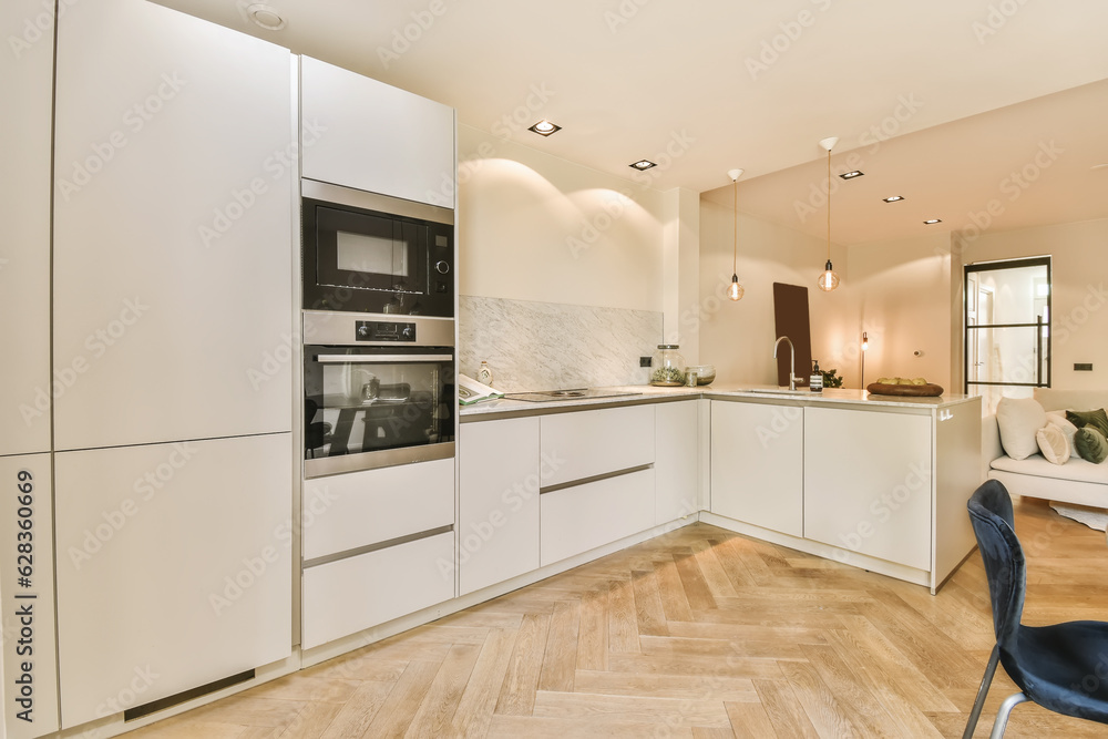 Φωτογραφία a modern kitchen with wood flooring and white cabinets in the center of the room