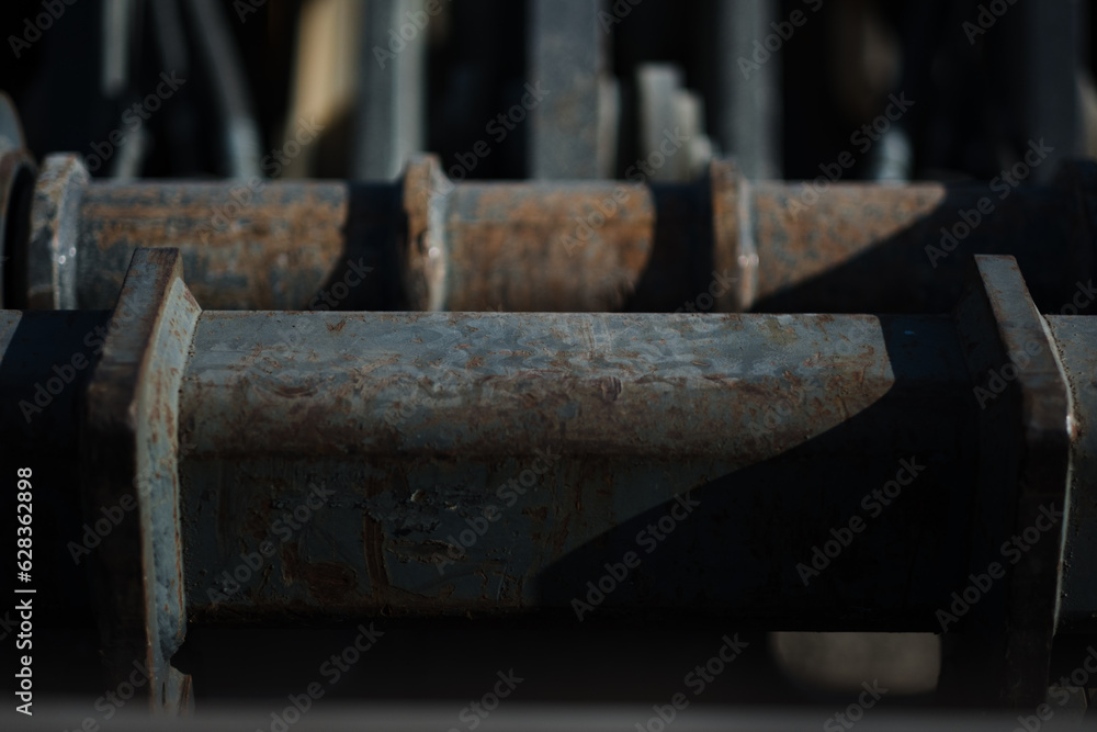 Rusted, heavily worn pistons power a piece of heavy machinery at a construction site. Rusted, heavily worn pistons power a piece of heavy machinery at a construction site.