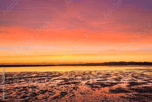 Peaceful and colorful dawn with beach in foreground