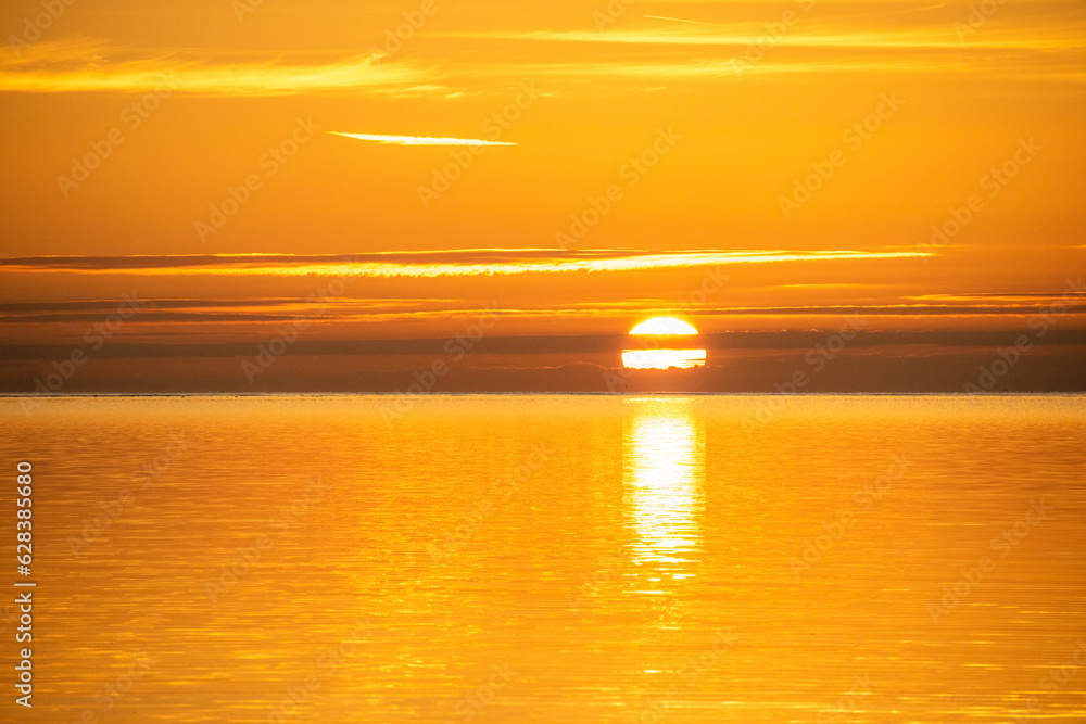 Sun rising above sea with reflection, golden sunrise