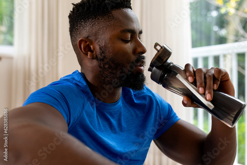 African american man drinking water at home