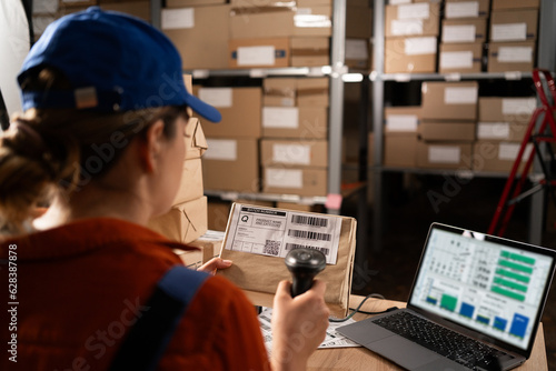 Woman worker working with warehouse management system with barcode reader and laptop computer Fototapet
