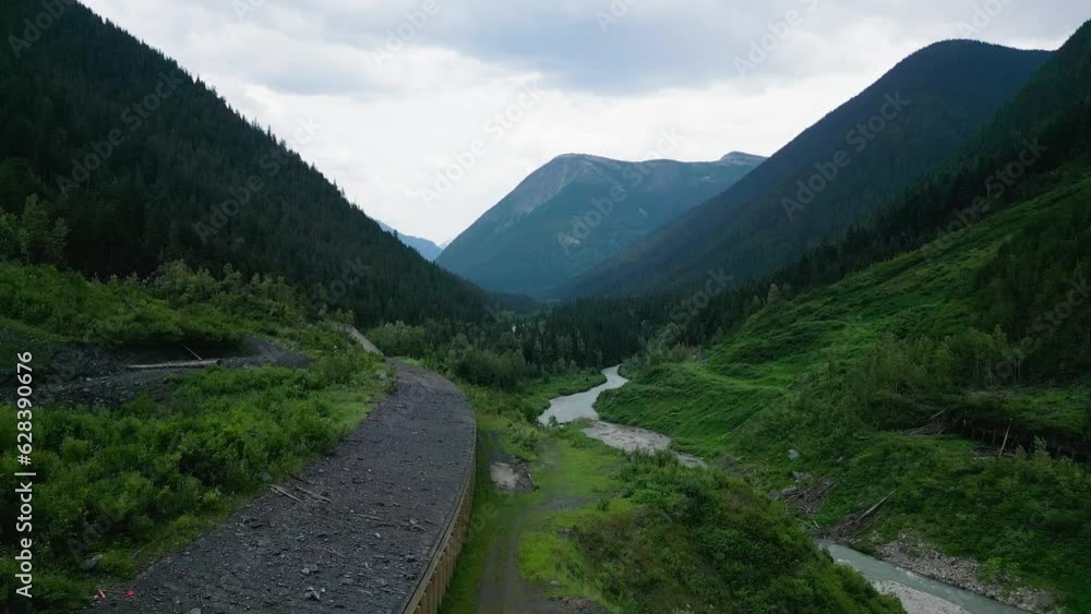Slow rise above an avalanche shelter beside a cold mountain river Slow rise above an avalanche shelter beside a cold mountain river