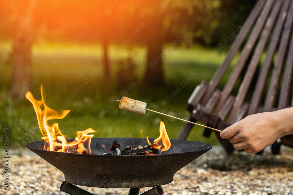 camping, marshmallow on a stick roasted over a camping fire Stock Photo