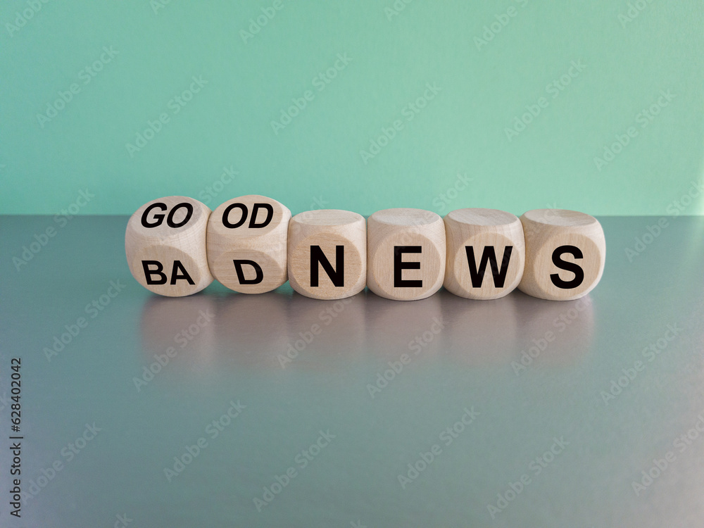 Good or bad news concept. Flipped cubes and changed the words bad news to good news. Beautiful blue background, grey table. Business and good news concept. Copy space.