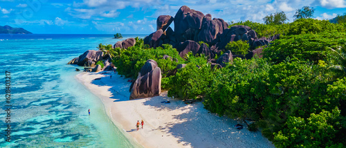 Anse Source d'Argent, La Digue Seychelles, a young couple of men and women on a tropical beach during a luxury vacation in Seychelles. Tropical beach Anse Source d'Argent, La Digue Seychelles