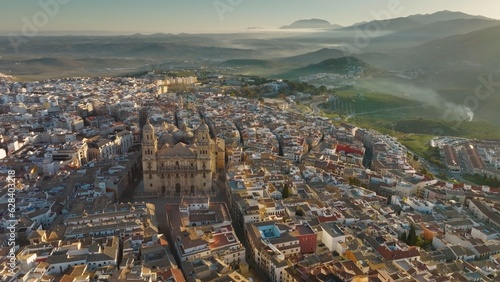 Aerial view of Jaen Cathedral early in the morning. Jaen, Andalucia, Spain with foggy green hills at background. UHD, 4K