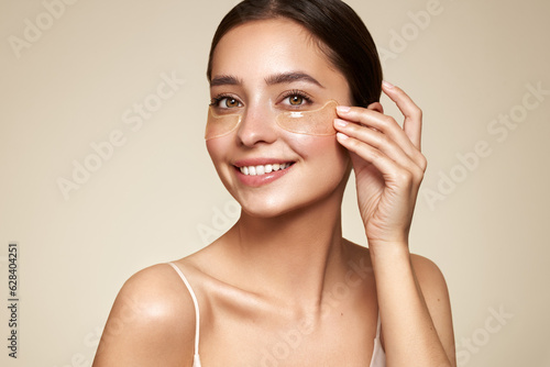 Foto A young beautiful smiling woman with cosmetic patches on her eyes