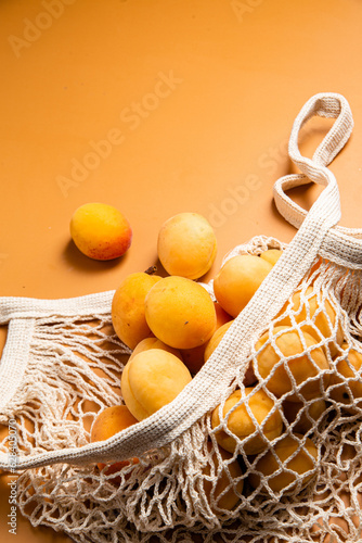 Apricots in an eco bag on a bright background. Purchase