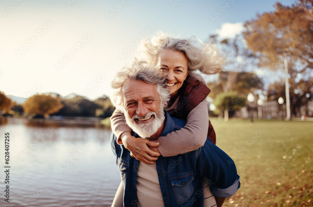 © Kalim - AI generated image of mature senior couple in park on piggyback