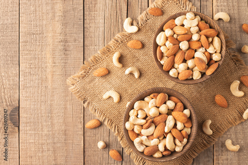 Large assortment of nuts in different bowls on stone table.