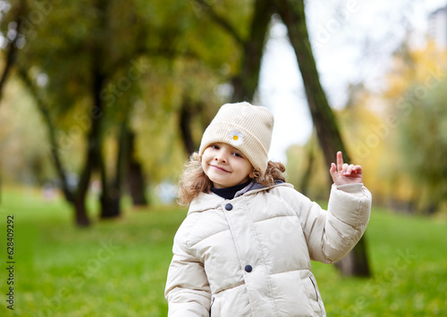 Baby girl are walking in the autumn city park. Little child having fun outdoors. Autumn season. Childhood