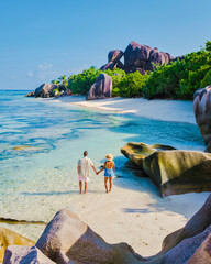 Anse Source d'Argent beach, La Digue Island, Seyshelles, Drone aerial view of La Digue Seychelles bird eye view.of tropical Island, couple men and woman walking at the beach during sunset at a luxury
