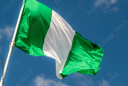 Nigeria flag in the blue sky. horizontal panoramic banner. Close-up of waving the flag of Nigeria. Great photo for news illustrations.