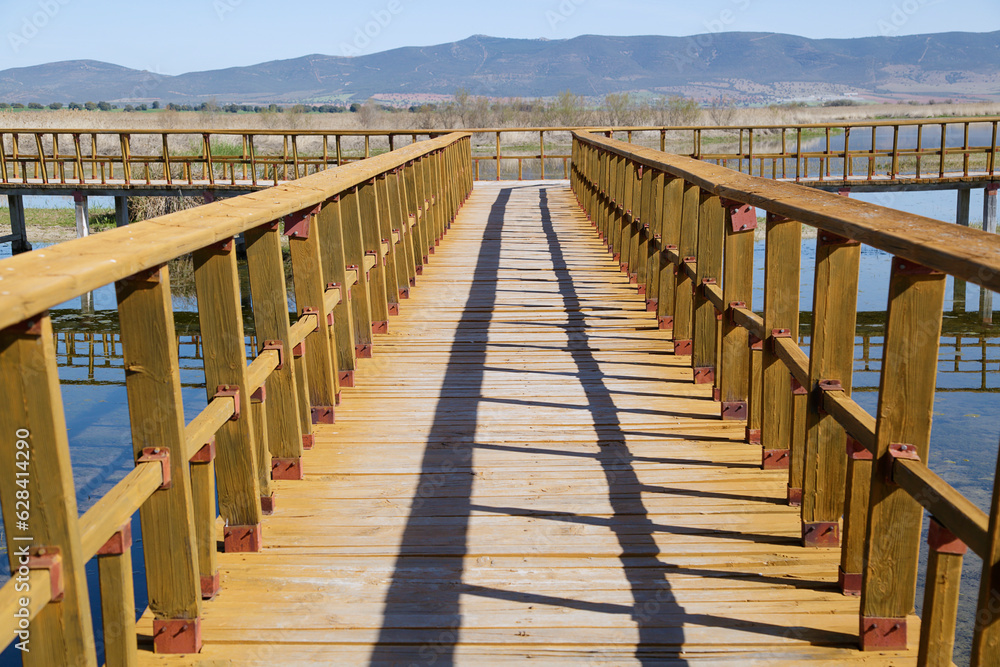  Wooden walkway bridge with railing on the river. National Park Tablas de Daimiel. Ciudad Real. Spain.