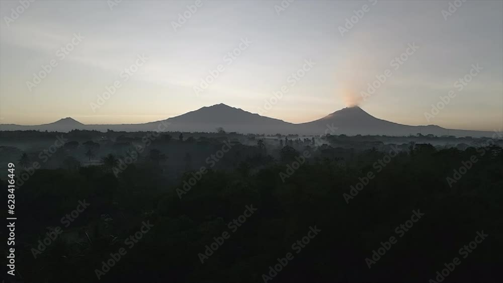 Three mountains in a row, one eruption mountain, early morning, foggy Three mountains in a row, one eruption mountain, early morning, foggy