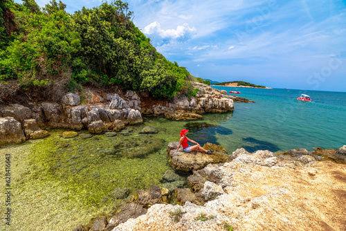 Obraz na płótnie woman sunbathing on the sandy shores of Ishul Ksamil Island from a top perspective. People are disembarking to explore the beautiful beach in the Ksamil archipelago of Albania. w salonie
