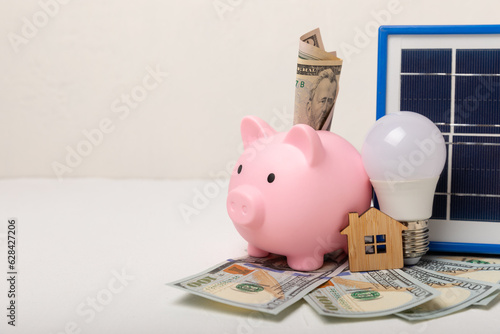 Flat lay composition with solar panel, led lamp, money and piggy bank on texture background. The concept of saving money and clean energy. The concept of ecology and sustainable development.Technologi photo