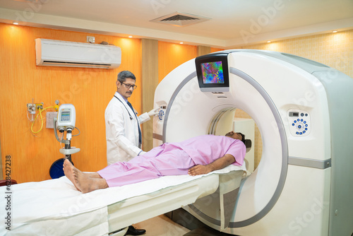 Medical technician starting MRI scan procedure of patient at clinic.