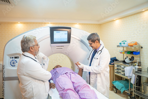 Doctor or Medical technician starting MRI scan procedure of patient at clinic.