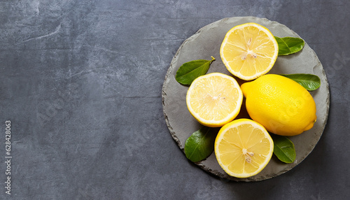 Fresh ripe lemons on dark stone background. Top view with copy space