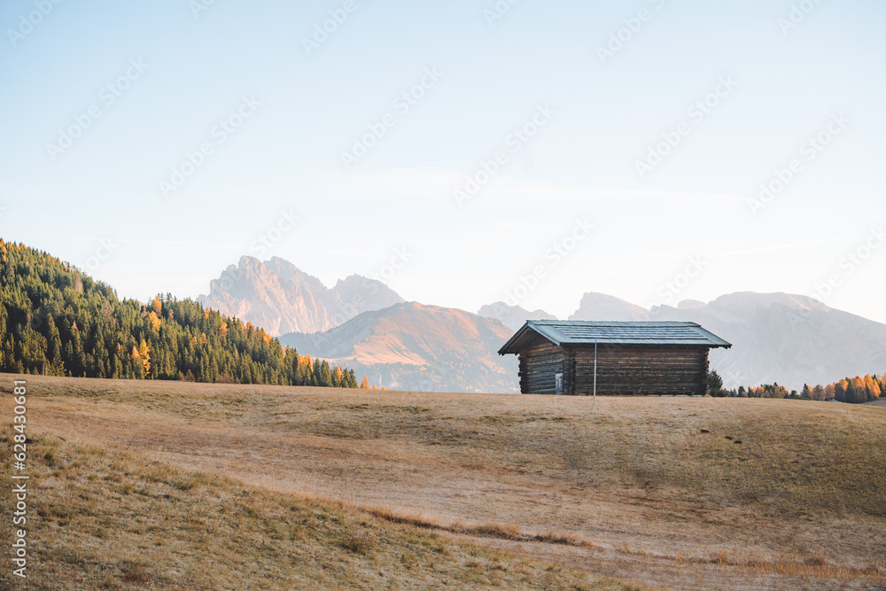 Mountain cabin in stunning landscape of Alpe di Siusi during sunrise, Dolomites