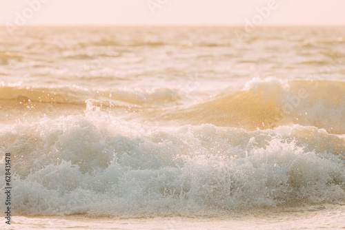 Evening sunlight sunshine above sea. Natural sunset sky warm colors. Amazing landscape scenery. Crashing waves. Sea ocean water surface with foaming small waves. Copy space. Nature background.