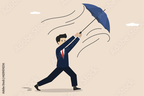 Business people hold work problems, business people face problems. Businessman holding his own umbrella which was blown by strong wind.