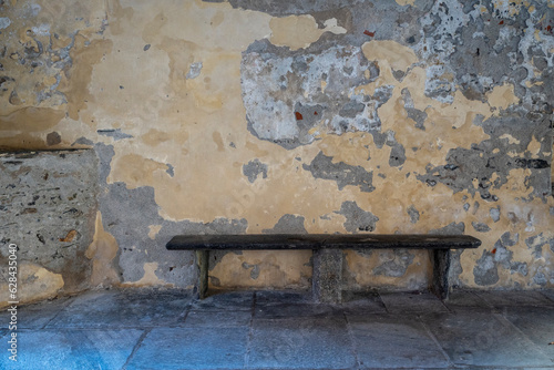 Italia; Vogogna. Angolo di antico paese del Piemonte. Panchina per sedersi e riposarsi sotto arcate di portici storici tipici di località turistica. photo