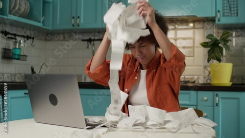 Exhausted Woman Throwing Receipts. African American 20s female tired of managing domestic finances.