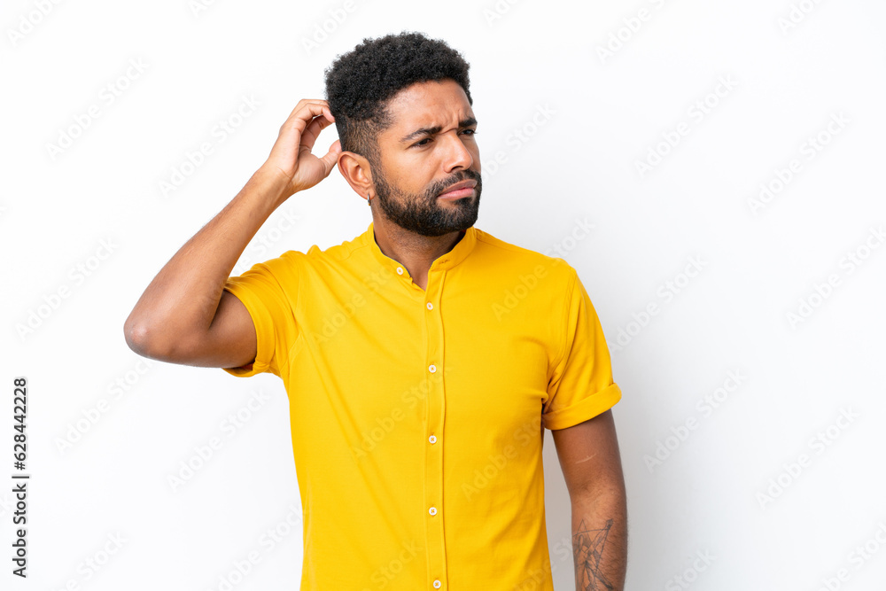 Young Brazilian man isolated on white background having doubts while scratching head Young Brazilian man isolated on white background having doubts while scratching head