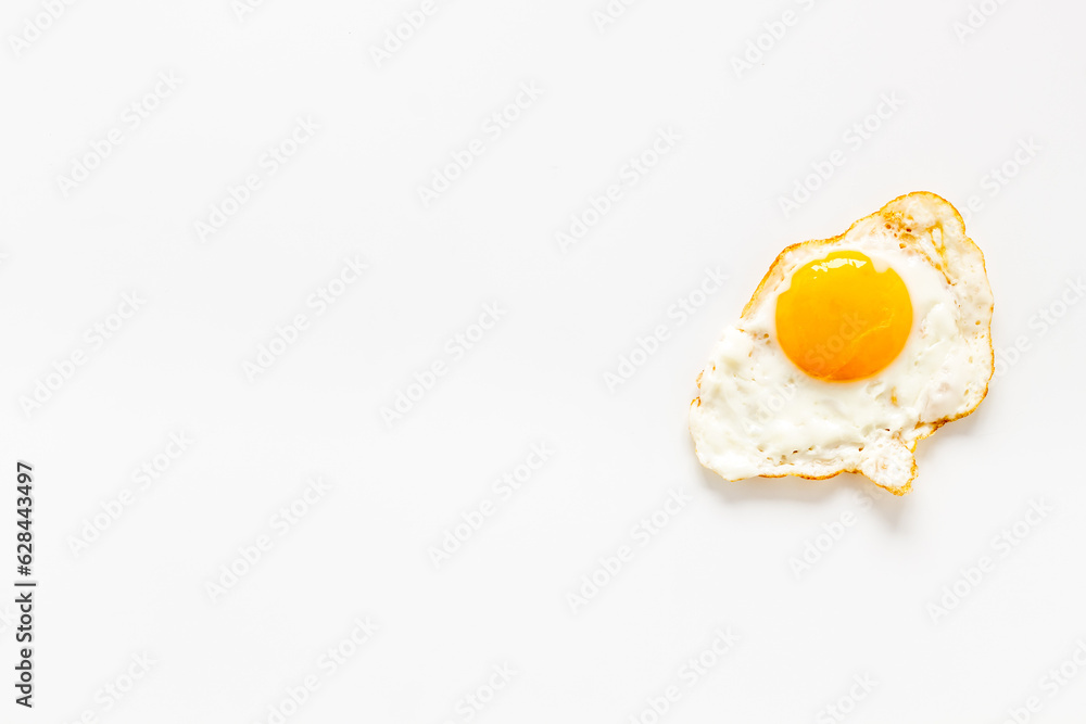 Fried egg close up on white background, top view. Breakfast concept