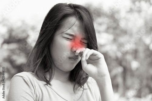 sick woman having runny nose due to virus outbreak; concept of flu symptoms, Nasopharynx cancer, COVID-19 infection photo