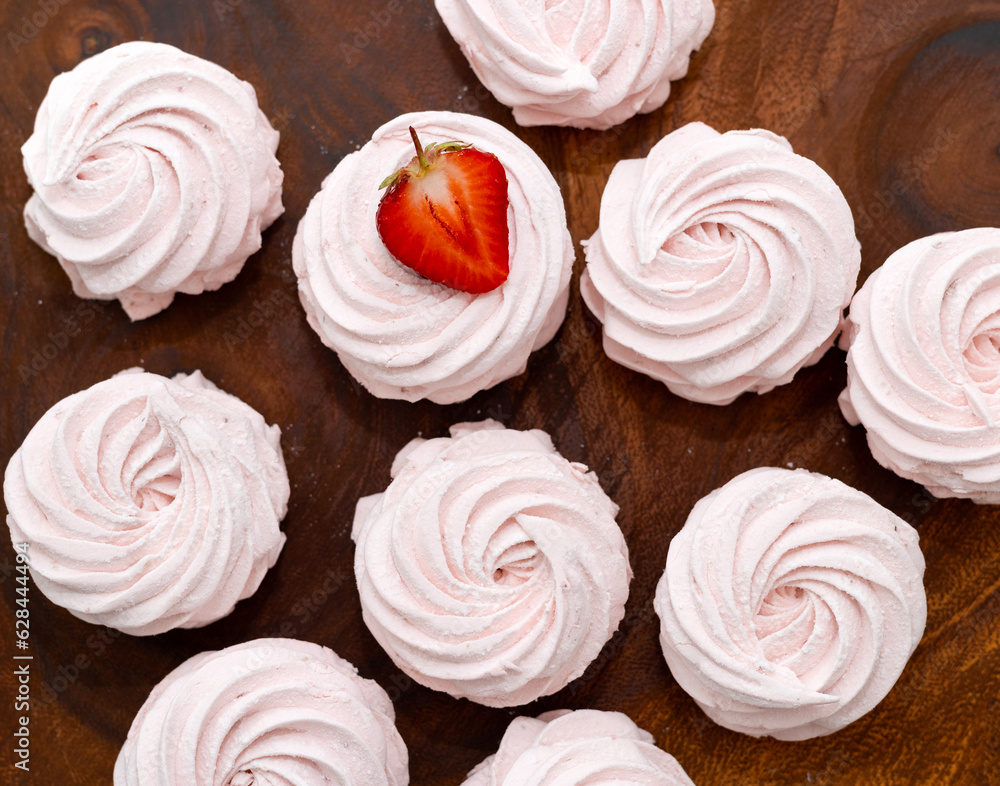 homemade marshmallow zephyr with strawberry taste on wooden boards. strawberries slice , sugar powder top view.food photography homemade marshmallow zephyr with strawberry taste on wooden boards. strawberries slice , sugar powder top view.food photography
