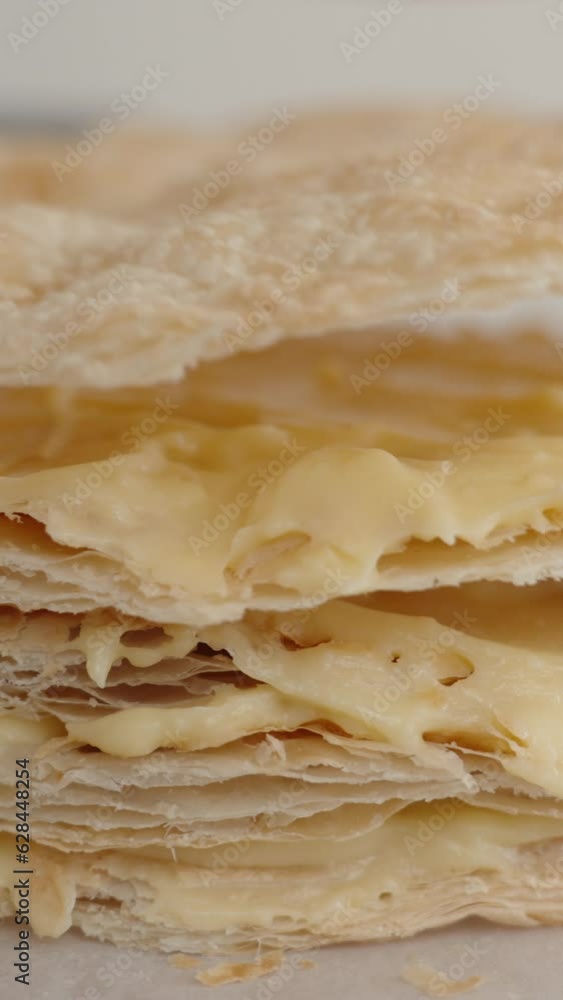 Vertical video. I am layering the puff pastry on top of each other, creating a Napoleon cake. Vertical video. I am layering the puff pastry on top of each other, creating a Napoleon cake.