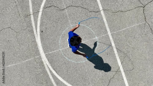 Aerial of a 12 year old boy jumping rope at a park in Los Angeles. Slow Motion photo