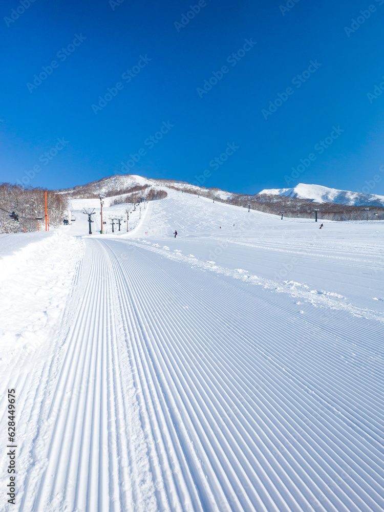 Freshly pressed piste in a quiet ski resort at early morning on a clear day (Niseko Moiwa, Hokkaido, Japan)
