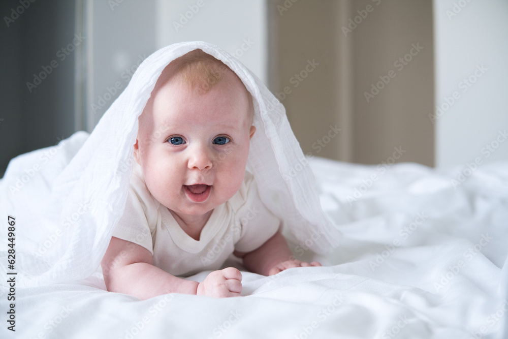 cute smiling baby lying on tummy on parent bed