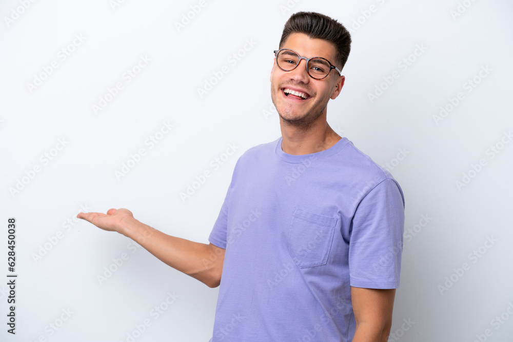 Young caucasian man isolated on white background extending hands to the side for inviting to come Young caucasian man isolated on white background extending hands to the side for inviting to come