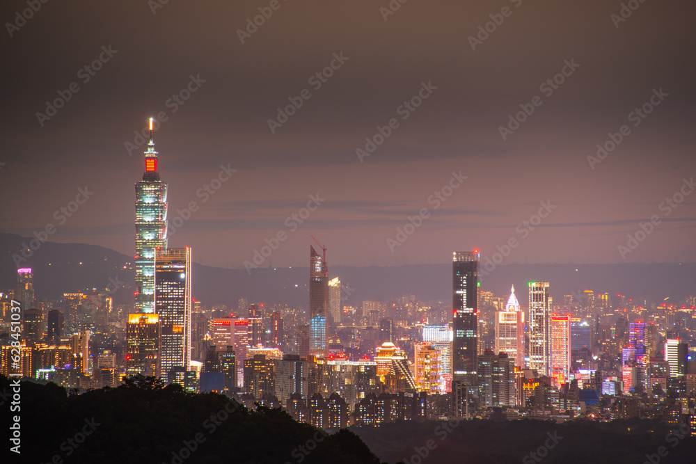 At dusk, the night view of Taipei gradually brightens. Dynamic clouds. View of the urban landscape from Dajianshan Mountain, New Taipei City.