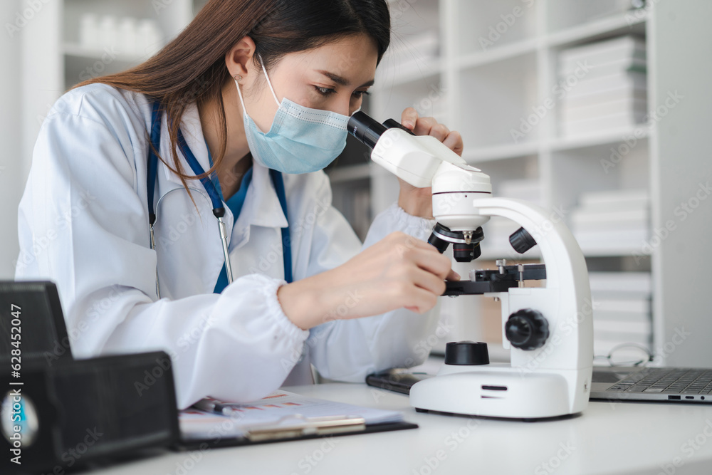 biochemical research scientists working with a microscope for vaccine development in pharmaceutical research labeling. biochemical research scientists working with a microscope for vaccine development in pharmaceutical research labeling.